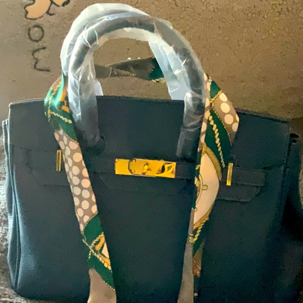 Pretty blue purse with gold hardware and a crossbody strap